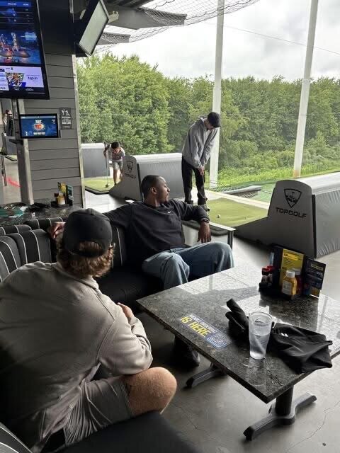Team members relaxing in a bay during a Topgolf outing